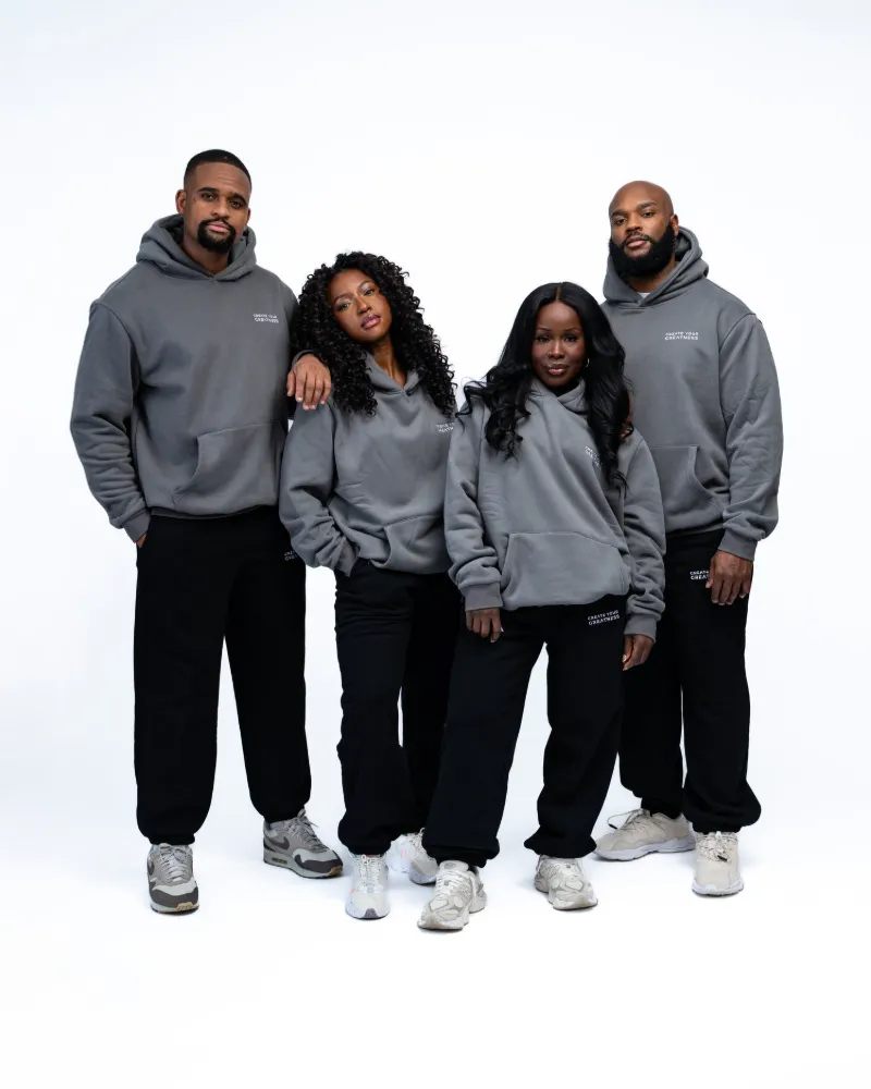 Four people wearing grey Signature Hoodies and black Signature Sweatpants in the studio