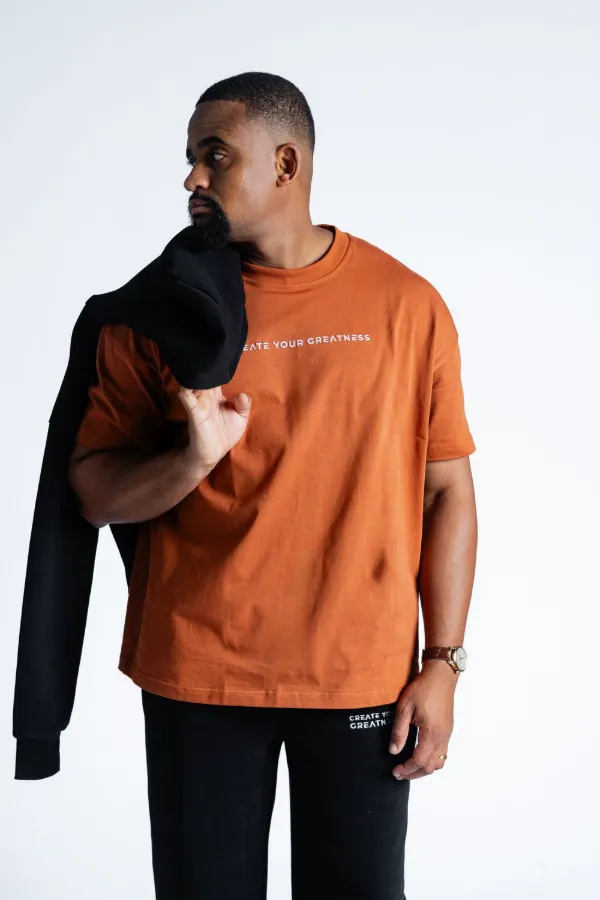 Model wearing the Heavy Cotton T-shirt in brown with a black hoodie over one shoulder