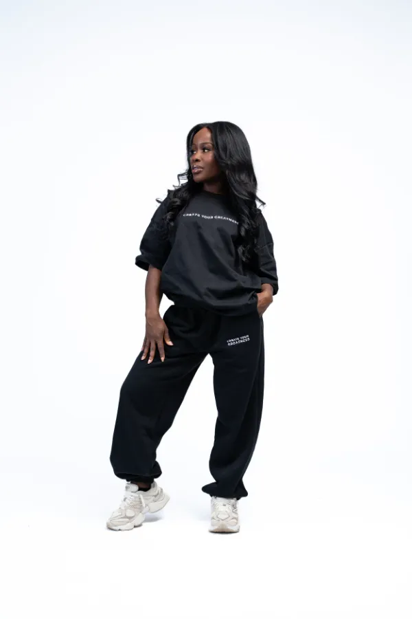 Model wearing the Signature Sweatpants in black with a black tee